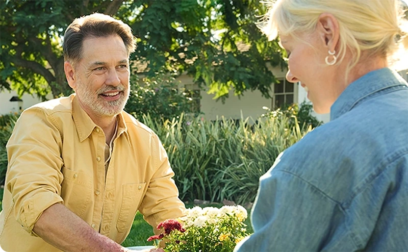 image of two adults exchanging a potted plant