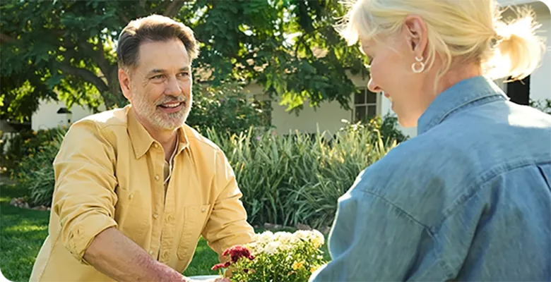 image of two adults exchanging a potted plant